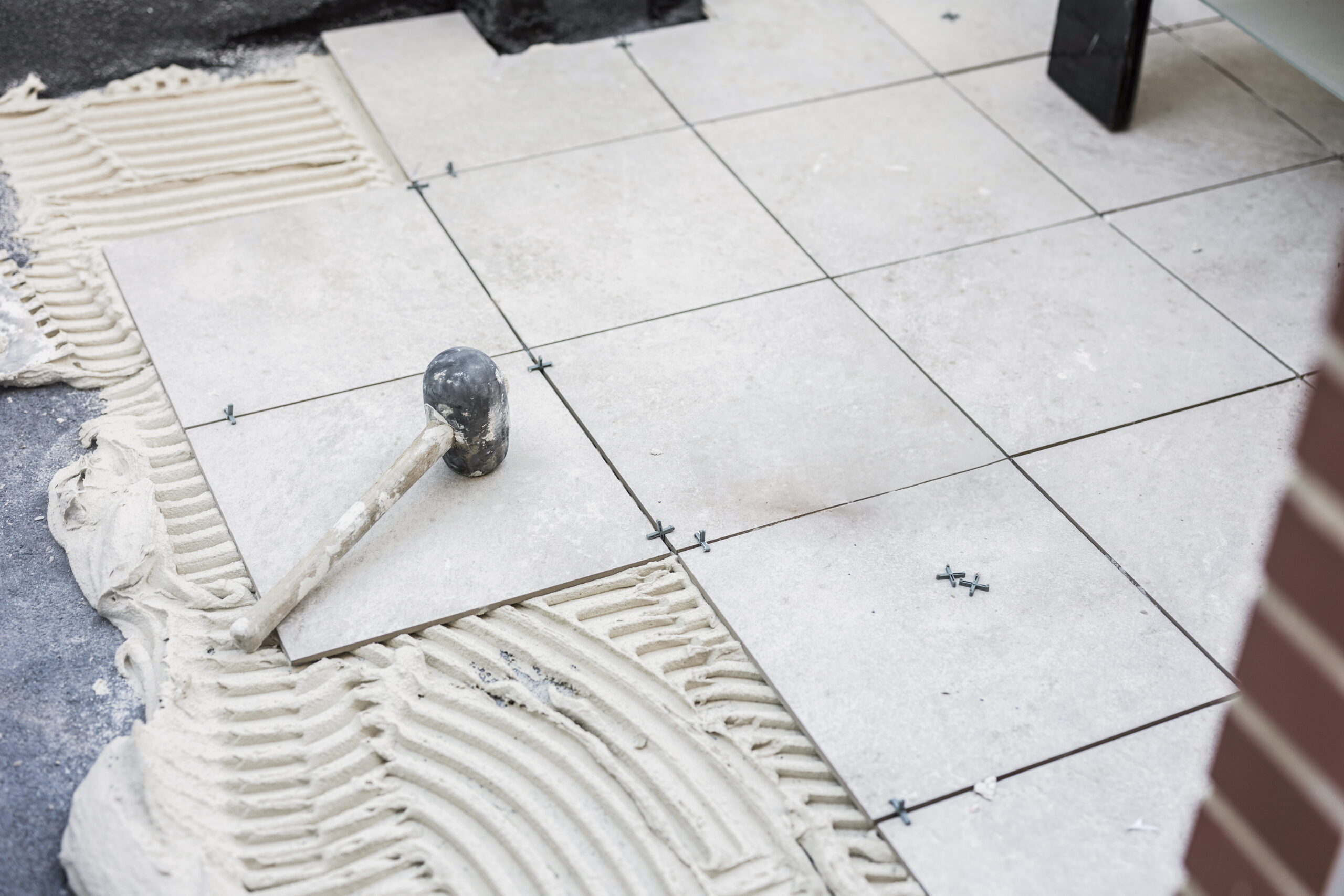 Tiler placing the ceramic tile on the floor. Grouting ceramic tiles. renewal. Construction. Tiler's hands. Home renovation and construction of new houses.